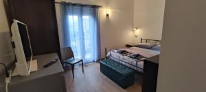 um quarto com uma cama com uma cadeira e uma janela em Casa vacanze Margherita em Laterza