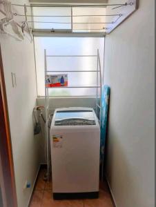 um pequeno frigorífico num canto de um quarto em Acogedor apartamento em La Pampilla