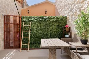 un jardín con una escalera junto a una pared verde en Corfu Town Luxury Studios -D en Corfú