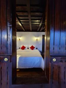 a bedroom with a white bed with red pillows at Seabreeze Marari in Alleppey