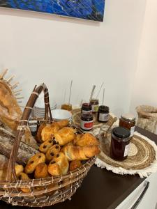 ein Korb mit Brot und Marmeladen auf dem Tisch in der Unterkunft Hôtel de la jetée in Centuri