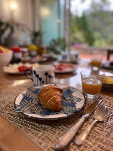 einen Tisch mit einem Teller mit einem Croissant drauf in der Unterkunft Natur & Jasmin Chambres d'hôtes naturistes en Provence in Lorgues
