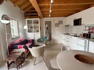 uma cozinha e sala de estar com mesa e cadeiras em Casa do Meio- Farm house- Tavira em Tavira