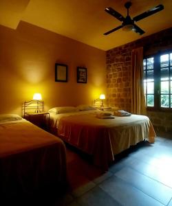 - une chambre avec 2 lits et un ventilateur de plafond dans l'établissement Posada Ribera del Gualeguaychu, à Gualeguaychú