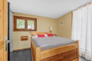 a bedroom with a wooden bed with red pillows at Grand Chalet Standing Avec Jacuzzi à Chamrousse ski 1750 in Chamrousse