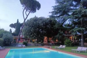 a swimming pool with two chairs and a house at Villa Al Piano in Lastra a Signa