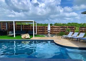 una piscina con sillas y un cenador en Nakolodge - 4 chambres - balneo - jardin et piscine privatifs, en Sainte-Anne