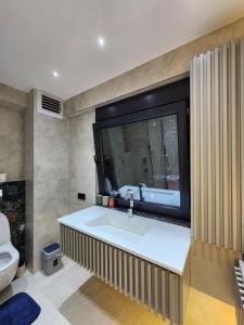 a bathroom with a sink and a television on the wall at Snowdrop 2 in Antalya
