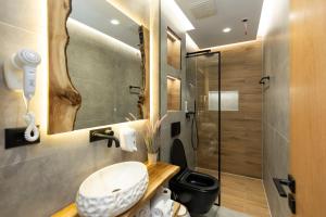 uma casa de banho com um WC e uma cabina de duche em vidro. em Hotel Joni em Ksamil