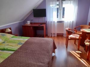 a bedroom with a bed and a table and a window at Janina in Pobierowo