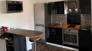 eine Küche mit Küchengeräten aus Edelstahl und einem Holztisch in der Unterkunft Studio de charme - coeur de ville in Perpignan