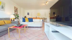 ein Wohnzimmer mit einem Sofa und einem TV in der Unterkunft Fantastico Duplex Familiar Dunas Artola in Marbella
