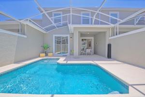 a swimming pool in front of a house at Upstay - ChampionsGate Home w Private Pool & BBQ in Kissimmee +34 photos