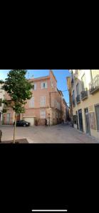 eine leere Straße mit einem Gebäude und einem Baum in der Unterkunft Studio de charme - coeur de ville in Perpignan