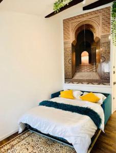 ein Schlafzimmer mit einem Bett und einem Gemälde an der Wand in der Unterkunft Studio de charme - coeur de ville in Perpignan