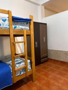 プカルパにあるALAMEDAS APARMENTsの二段ベッド2台とキャビネットが備わる客室です。