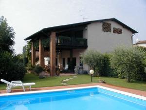 ein Haus mit einem Pool vor einem Haus in der Unterkunft Manuela Le Quattro Coppe in Desenzano del Garda