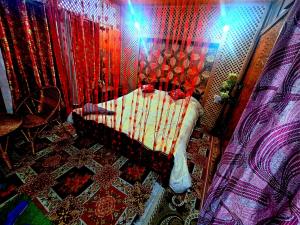 a bedroom with a bed with a red and white blanket at King of kings Houseboat in Srinagar