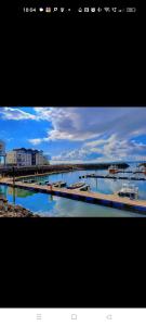 two pictures of a harbor with boats in the water at Mill cottage in Carrickfergus