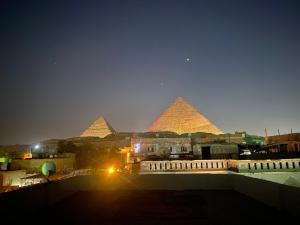 einen Blick auf die Pyramiden von Giza in der Nacht in der Unterkunft Alma pyramids view inn in Kairo