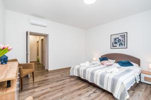 Dormitorio blanco con cama y mesa en Perla Hradce 103, en Hradec Králové