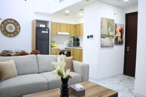 a living room with a couch and a table at MasdarCity Bliss 2BR apartment in Abu Dhabi