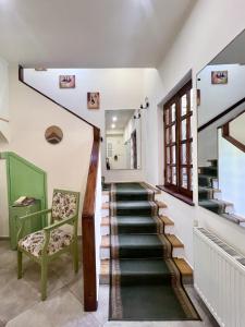 una escalera en una casa con una silla verde en Madera Hotel, en Tiflis