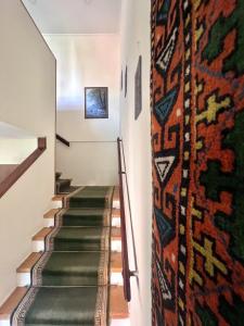 a hallway with stairs with a rug on the wall at Madera Hotel in Tbilisi City