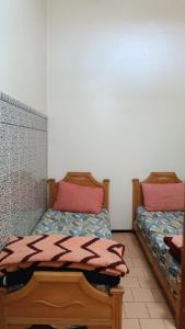 2 Betten nebeneinander in einem Zimmer in der Unterkunft Auberges Des Jeunes Casablanca in Casablanca