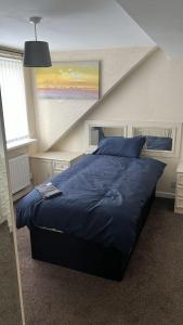 una camera con letto e piumone blu di Stunning Four Bedroom Spacious House In Quinton, Birmingham- Parking Included a Birmingham