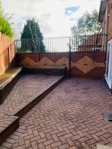 un muro di mattoni con gradini e una panca su un patio di Stunning Four Bedroom Spacious House In Quinton, Birmingham- Parking Included a Birmingham