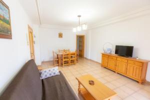 una sala de estar con un sofá y una mesa en Apartmentos Corona, en Cazorla