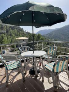 einen Tisch und Stühle mit einem Sonnenschirm auf einer Terrasse in der Unterkunft Areesh Hotel & Restaurant in Lower Topa