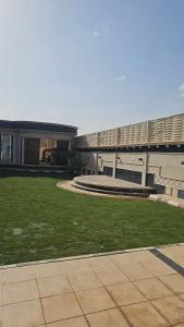 un edificio con un patio de césped delante de él en شاليه رفد, en Ruwak