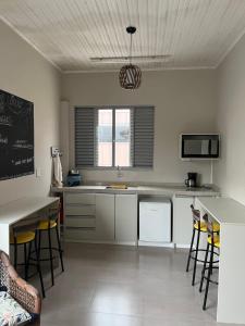 uma cozinha com armários brancos e uma mesa e cadeiras em ACONCHEGO DA LAPA em Lapa