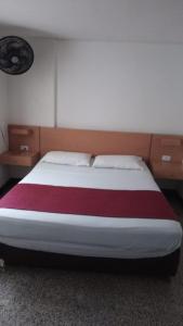 1 dormitorio con 1 cama grande con manta roja y blanca en HOTEL del OESTE B&B en Cali