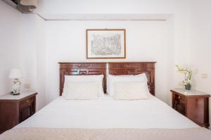 索倫托的住宿－Maison Sersale，卧室配有一张白色大床和木制家具
