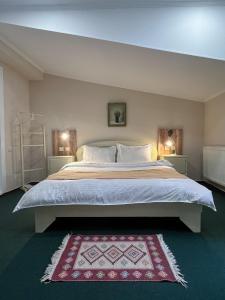 1 dormitorio con 1 cama grande con alfombra roja en Madera Hotel, en Tiflis