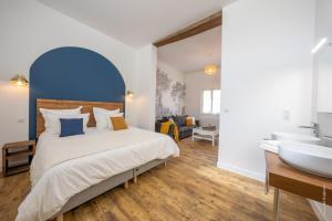 a bedroom with a bed and a bathroom with a sink at Domaine Beaumont - Vignoble & Maison d'Hôtes Vigneronne in Distré