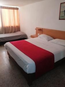 1 dormitorio con 1 cama grande con manta roja en HOTEL del OESTE B&B en Cali
