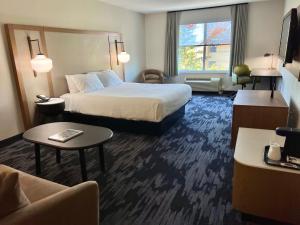 a hotel room with a bed and a living room at Fairfield Inn & Suites Detroit Farmington Hills in Farmington Hills