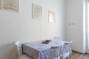 a white dining room with a table and chairs at Appartamento Al Mare in Portoferraio