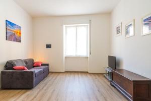 a living room with a couch and a television at Appartamento Al Mare in Portoferraio +9 photos