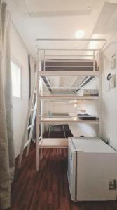 Habitación pequeña con litera y escalera en K Stay Blue Boat Myeongdong, en Seúl
