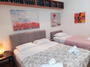 a bedroom with two beds and a painting on the wall at Lovely apartment in Athens center in Athens