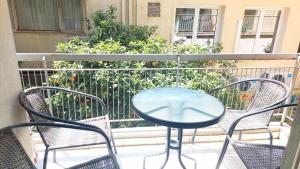 アテネにあるLovely apartment in Athens centerのガラスのテーブルと椅子付きのバルコニー