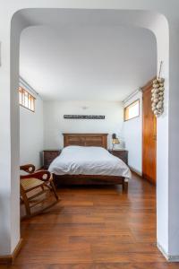 1 dormitorio con 1 cama y suelo de madera en Apartaestudios La Candelaria, en Bogotá