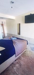 1 dormitorio con 1 cama con manta azul y espejo en Casa Dos Artistas, en Penedo