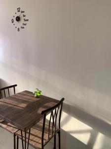 einem Holztisch mit zwei Stühlen und einer Uhr an der Wand in der Unterkunft 1-BR Condo unit in Mandaue City for Rent - The Midpoint Residences in Mandaue City