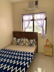 ein kleines Schlafzimmer mit einem Bett und einem Fenster in der Unterkunft 1-BR Condo unit in Mandaue City for Rent - The Midpoint Residences in Mandaue City